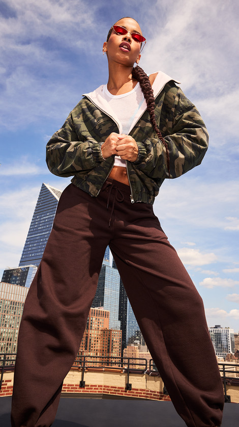 Woman posing in a brown pants and camo jacket